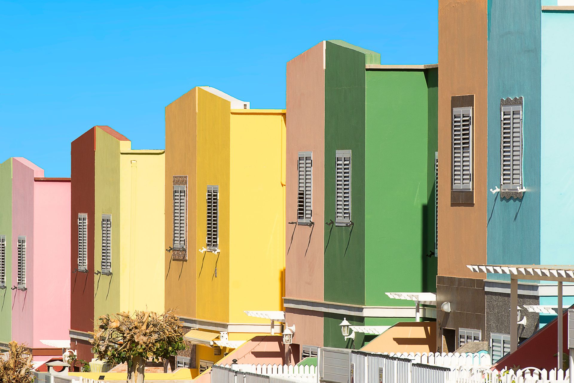 Vibrant and modern villas in a sunny suburban setting, showcasing diverse architectural facades.