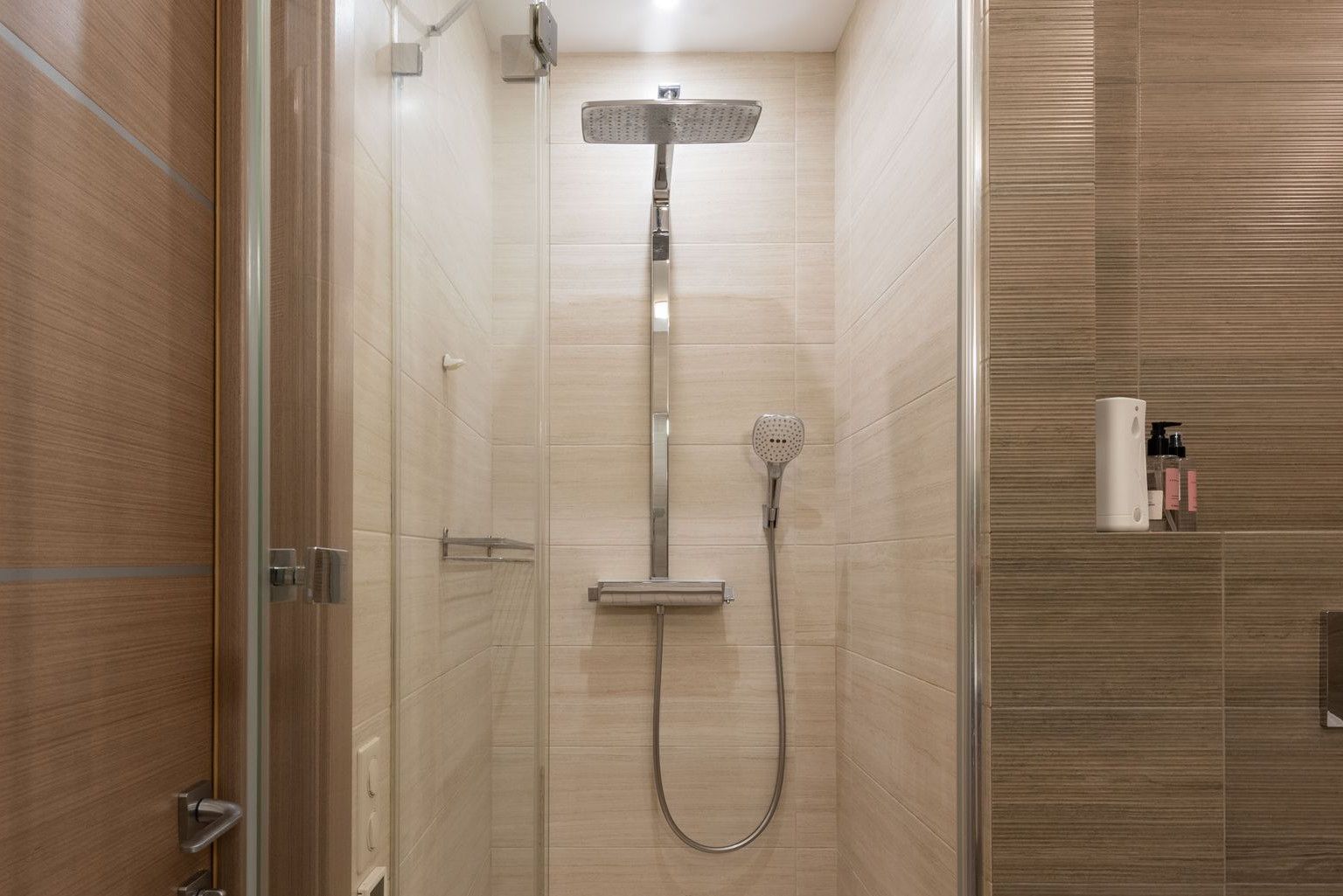 Sleek modern shower with glass door in a contemporary bathroom setting, featuring elegant interior design.